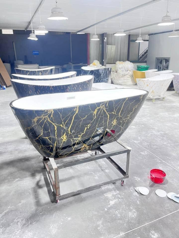 Luxury freestanding solid surface bathtub featuring a black and gold marble pattern finish