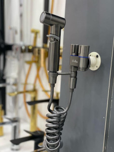 This product is a matte black handheld bidet sprayer set with a dual control valve