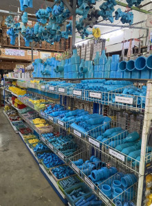 blue PVC pipe fittings and connectors organized on shelves in a building materials store