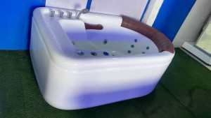 Luxury acrylic Jacuzzi whirlpool bathtub featuring built-in hydro-massage jets and ambient lighting