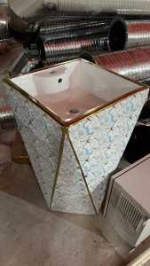 Freestanding ceramicc pedestal bathroom sink with a gold trim and patterned finish 