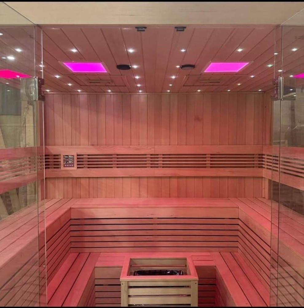 sauna room , which typically features wooden contrustruction, tempered glass panels, and may including heaters and chrometherapy lighting